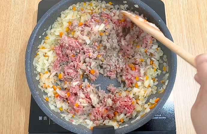 にんにく、しょうが、ひき肉を炒める様子