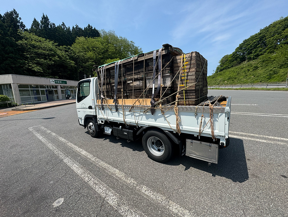 トラックの荷台にたくさんの巣箱が乗っている写真