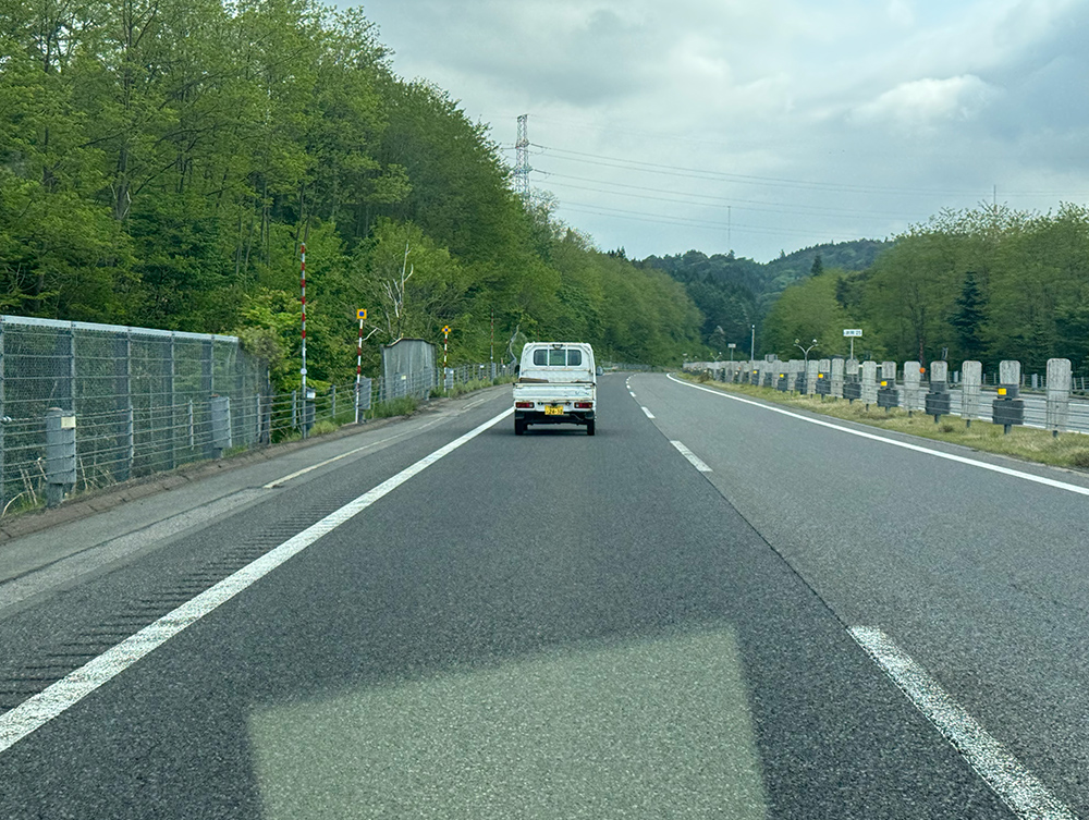高速道路で前を走っている軽トラの写真