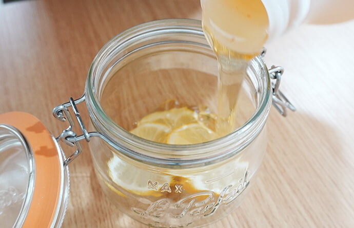 レモンとはちみつを瓶に入れる様子