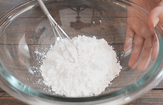 米粉、ベーキングパウダーを入れ、混ぜ合わせる様子