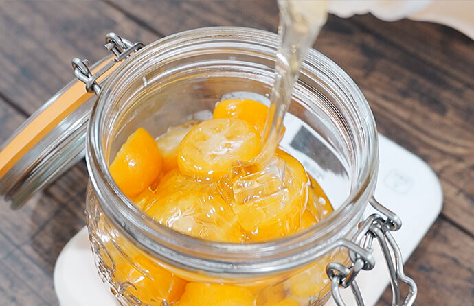 瓶にきんかんをつめる様子